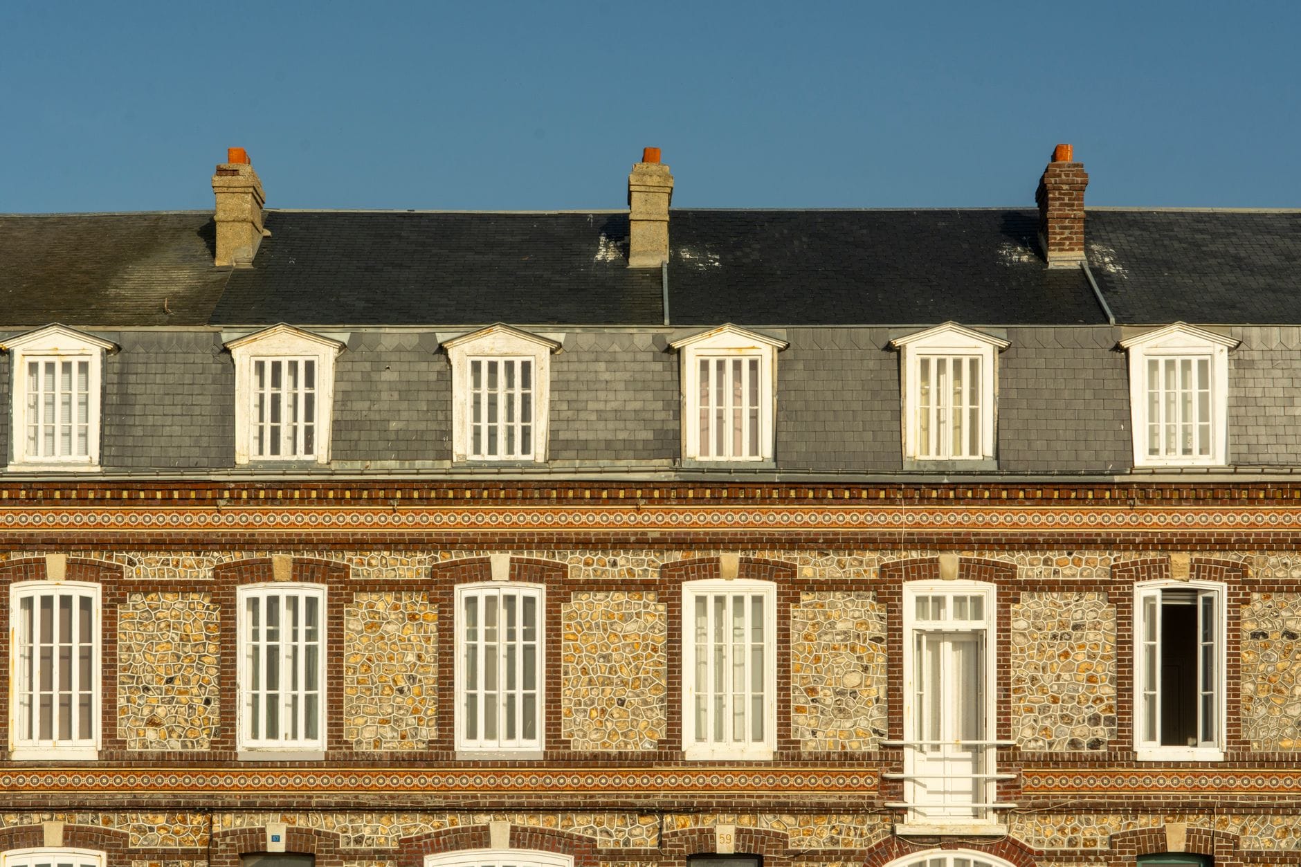 Façade normande en brique et silex sous une couverture d'ardoise à Fécamp