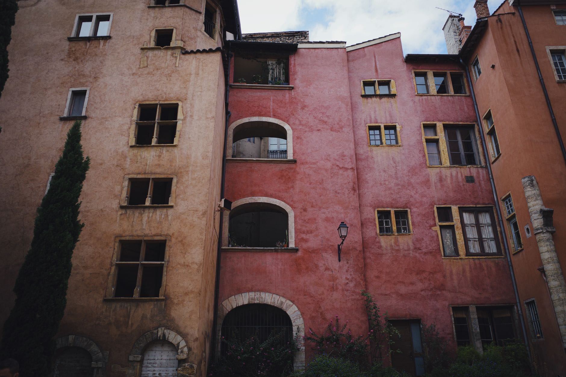 Façades d'immeubles anciens du Vieux Lyon, enduits ocre et rose, fenêtres à meneaux et galeries à arcades