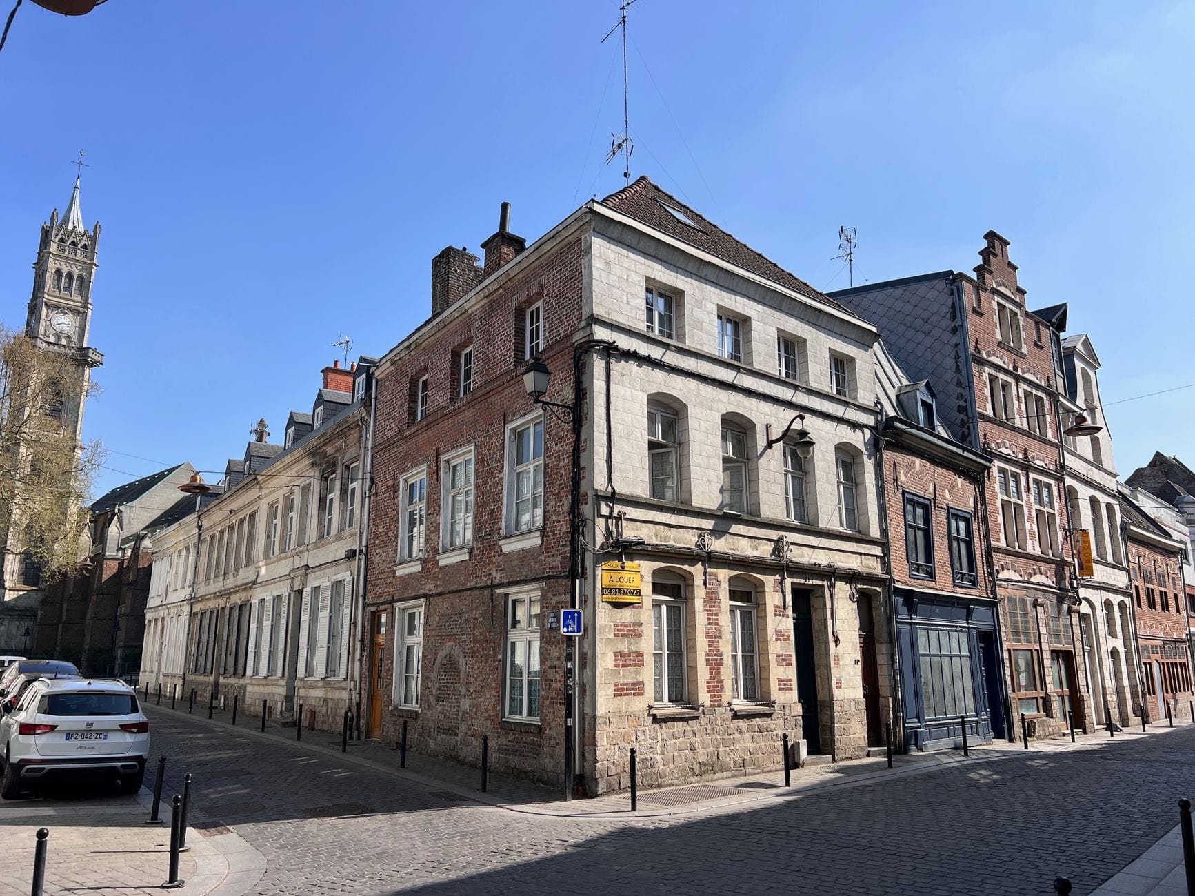 Immeuble ancien en brique et pierre à un angle de rue de Valenciennes
